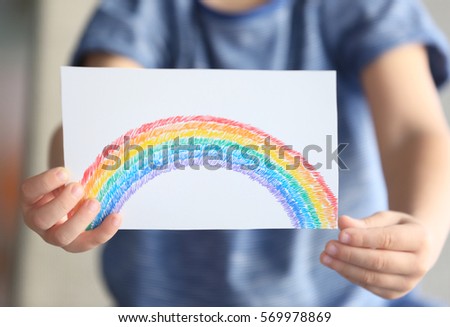 Child holding drawing of colorful rainbow, closeup. Adoption concept