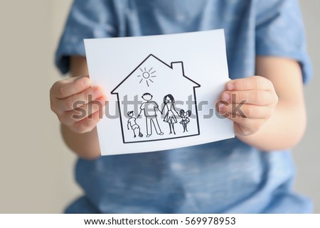 Child holding drawing of house with family, closeup. Adoption concept