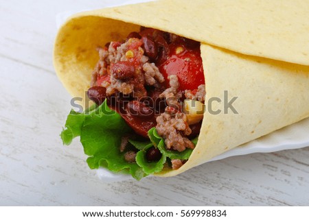 Burrito with beef, salad, beans and sauce