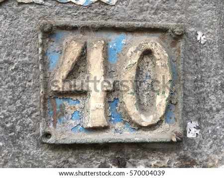 Vintage grunge square metal rusty plate of number of street address with number 40 closeup