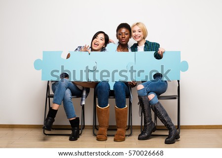 group of three different ethnic woman waiting in chairs with puzzle pieces