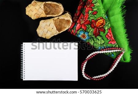 Black background with white empty sheet, top view, mock up, close up, picture for text, letter, russian tradition, bast shoe, necklace, shawl, colorful, folk