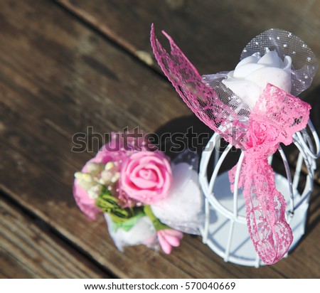 White and pink flowers next to mini bird cage on old wood table background. Weddings or valentines day card with copy space.