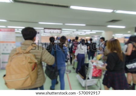 Blurred defocused image of travellers queue at immigration control at airport, for background.