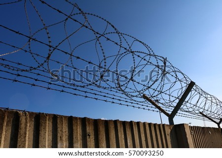 Wall with rolled barbed wire 
