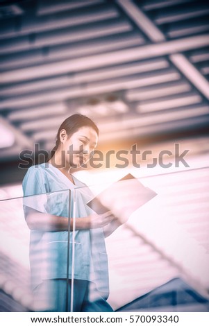 Nurse looking at diary while standing in hospital