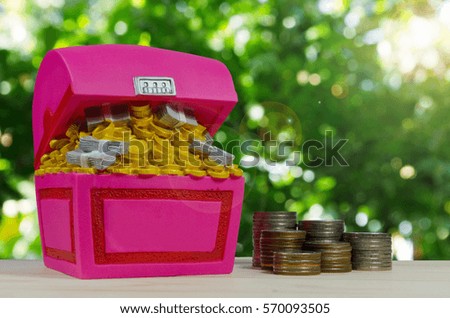 Piggy bank or Treasure Chest shaped money box with money coins in saving money concept.