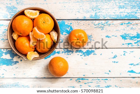 Mandarins in a bowl on wooden table.top view. Royalty-Free Stock Photo #570098821