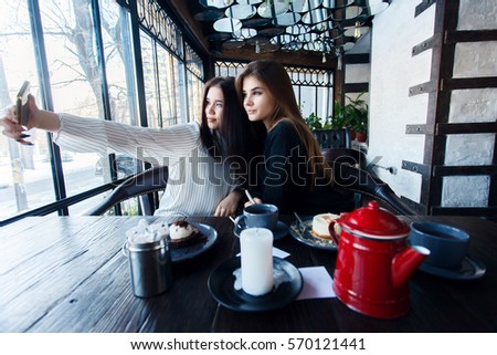 technologies, lifestyle, food, people, teens and coffee concept - Two young women taking selfie with smart phone in the city center. Happiness concept about people and technology