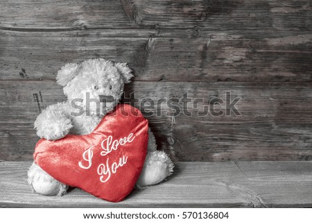 mascot teddy bear holding a heart symbolizing love