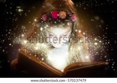 Pretty little girl reading magic book Royalty-Free Stock Photo #570137479