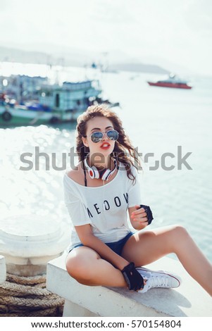 pretty hipster woman posing in the pier, outdoor close up portrait, sneakers, sunglasses