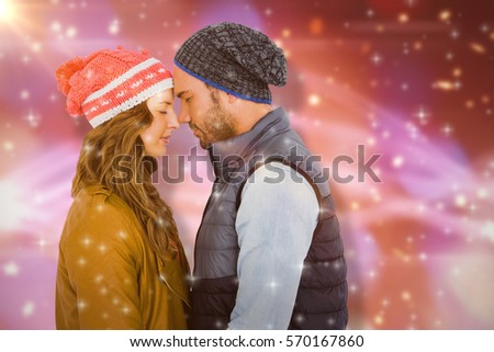 Happy young couple standing face to face against glowing background