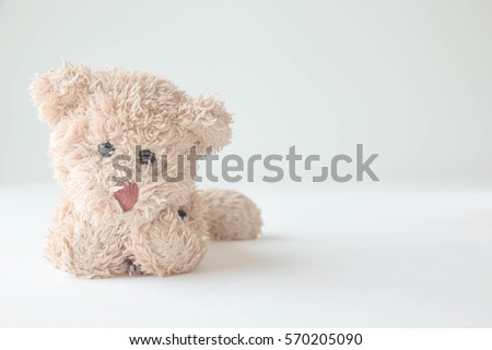 Cute teddy bear lying on a bed with white background
