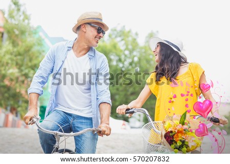 Valentines heart design against happy couple with bicycles 3d