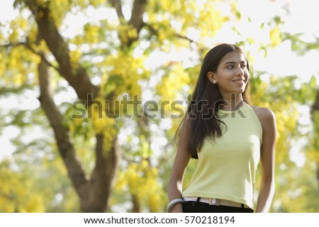 teen girl standing under blooming tree
