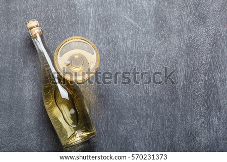 Bottle and glass of sparkling champagne wine on an empty blackboard with empty space for text and graphics Royalty-Free Stock Photo #570231373