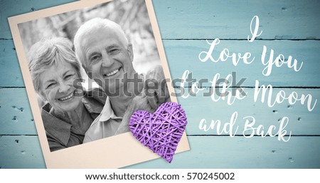 Happy old couple smiling against painted blue wooden planks