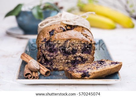banana bread with blueberries and cinnamon on bright background Royalty-Free Stock Photo #570245074