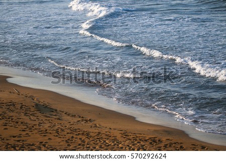 Sea with small foam wave and beach.