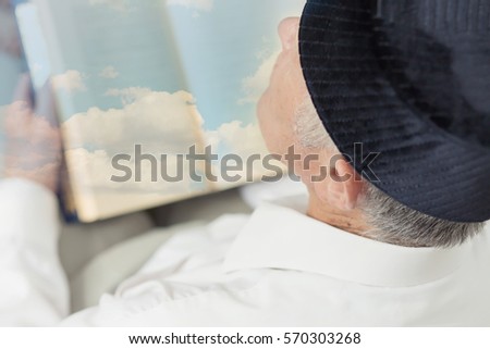 An old man hands reading the Koran