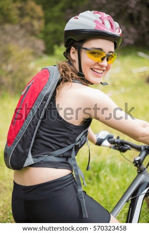 Smiling woman cycling in the countryside