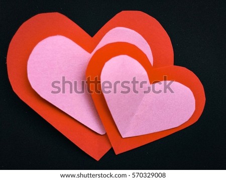Cutting paper Red Pink  hearts {Paper Heart stacked}, Heart of paper folding Isolated on Black Background. Cards for Valentine's Day. There is space or text "Happy Valentine's Day"