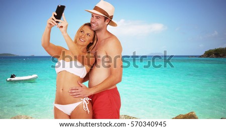 Happy millennial couple taking selfies by the beach