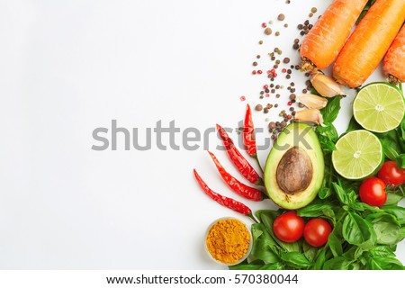 Detox food & drink healthy diet: Fresh vegetables fruits herbs and spices. Olive oil, garlic pepper tomatoes carrot lime avocado and herbs. Top view. Closeup. White paper background Free text layout. Royalty-Free Stock Photo #570380044