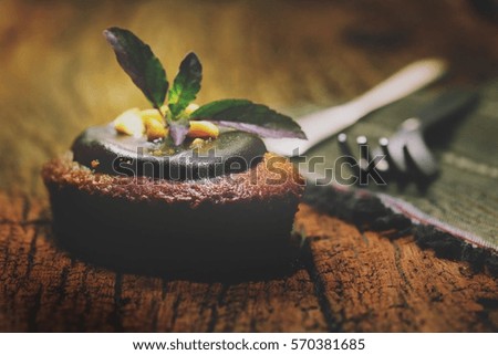 Chocolate brownie with chocolate syrup and sliced almond, selective focus and toned image. Low key picture.