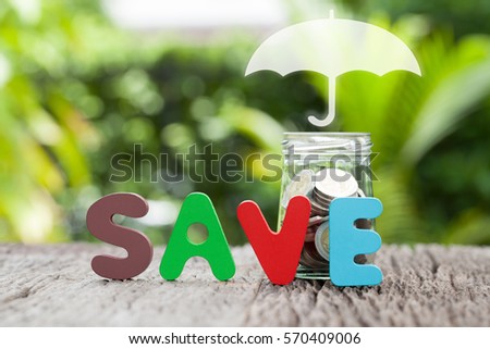 Coverage, insurance or Protection concept, Coins in a glass jar, umbrella nature background