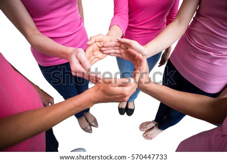 Women in pink outfits joining in a circle on white background for breast cancer awareness