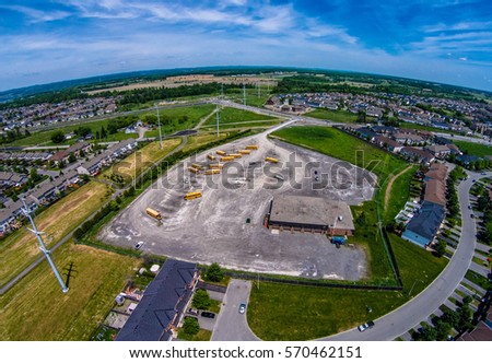 School bus parking lot surrounded by a residential area aerial skyline shot
