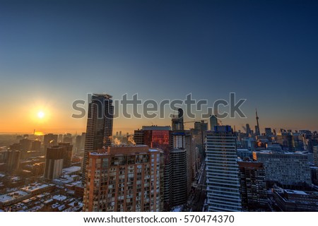 Sunrise in a downtown view from high above with multiple skyscrapers beneath blue skies 