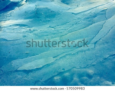 Blue sheets of shifting ice look like clouds in the sky. Royalty-Free Stock Photo #570509983