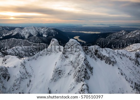 Aerial view of Lions Mountains with Vancouver Downtown, BC, Canada, in the background. Picture taken during a cloudy winter sunrise.