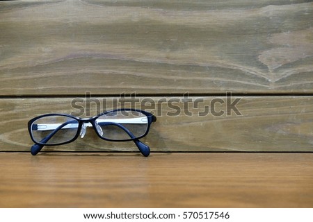eye glasses on the table with the background of the vintage style wooden wall.  lifestyle concept