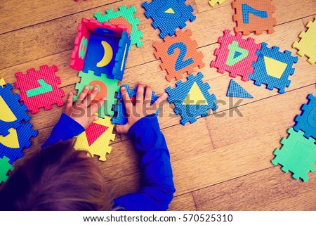 little girl playing with puzzle, early education Royalty-Free Stock Photo #570525310