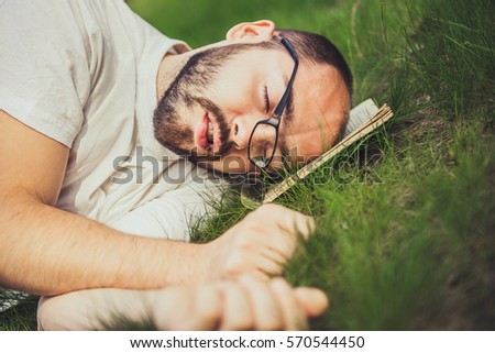 weary man relaxing outdoors lying on the grass