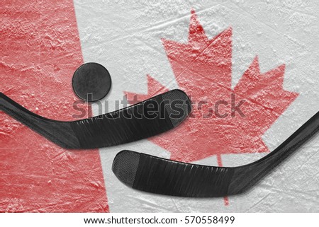 Hockey puck, hockey sticks, and the image of the Canadian flag on the ice. Concept