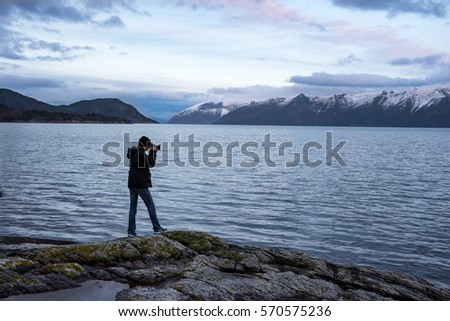 Photographer in beautiful Norwegian fjord and mountain landscape