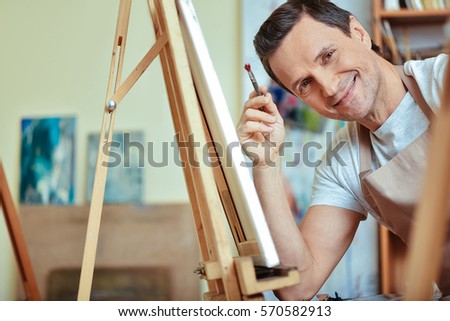 Happy artist smiling in painting studio.