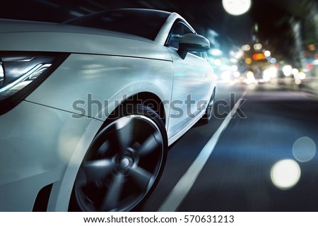 Sportscar drives through a night city  Royalty-Free Stock Photo #570631213