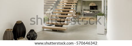 Modern wooden stairs in the hallway in big house Royalty-Free Stock Photo #570646342