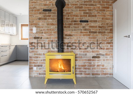 Loft with red brick wall and yellow freestanding stove Royalty-Free Stock Photo #570652567