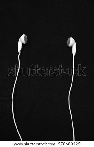 White earphones on a black background.