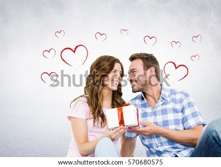 Composite image of happy couple with gift against hearts in background