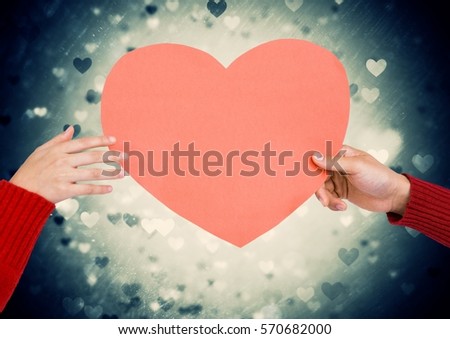 Close-up of couple holding heart against digitally generated green illuminated background