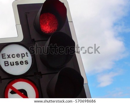 Red traffic light with blue cloudy sky