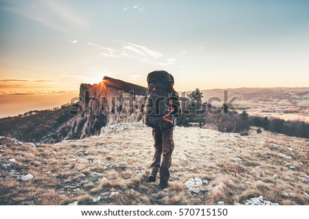 Man with backpack hiking in mountains Travel Lifestyle success concept adventure active vacations outdoor mountaineering sport sunset landscape Royalty-Free Stock Photo #570715150